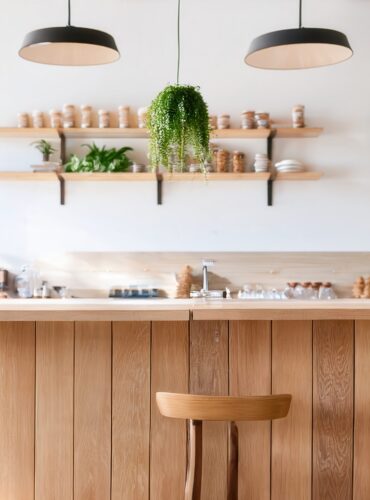 Cafe interior with wooden counters and hanging greenery showcasing biophilic design